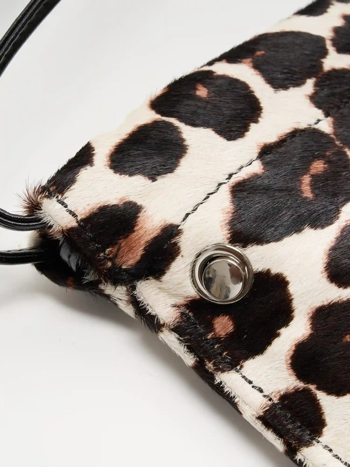 Close-up of Light Beige Leopard top edge, round metal fitting, and hair-on texture