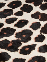 Close-up of dark leopard spots and brown accents on light beige hair-on hide
