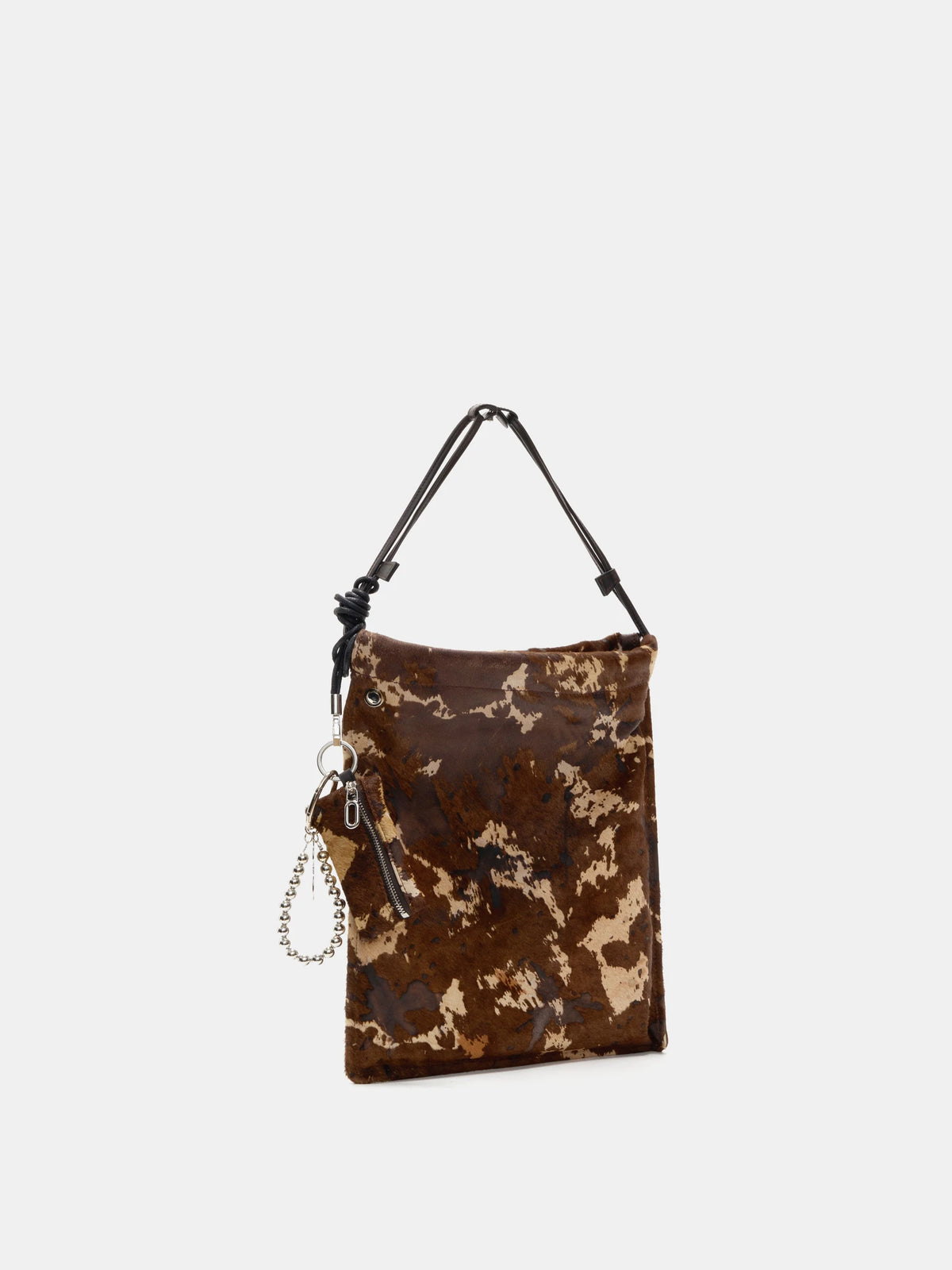 Angled view of Mocha Cow Print bucket bag with matching zip pouch and bead loop