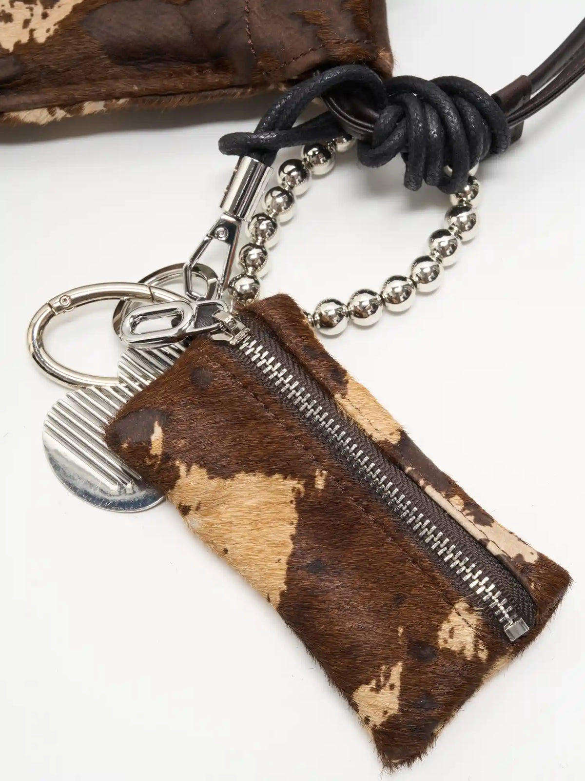 Mocha Cow Print zip pouch, silver-tone bead loop, and black knotted cord