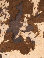 Close-up of irregular mocha brown and beige cow-print patches
