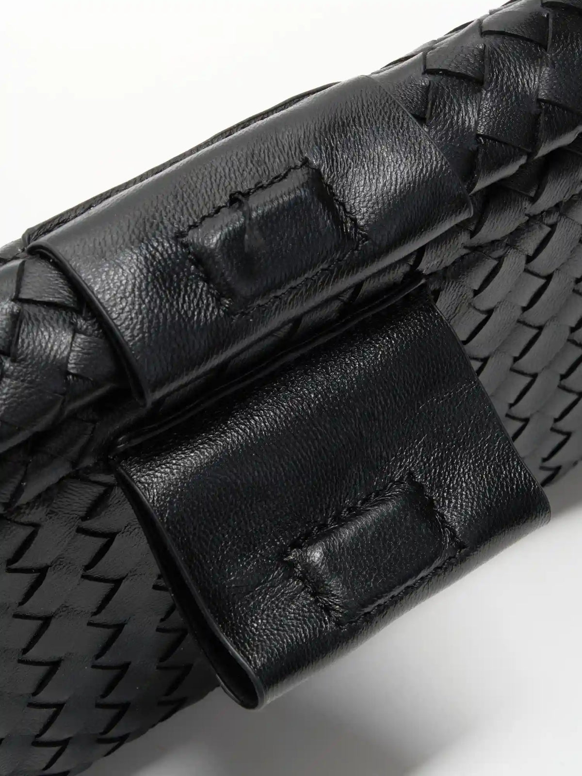 Black Weave handwoven sheepskin chain baguette bag close-up of the magnetic tab and woven top edge