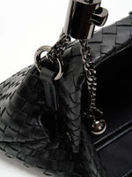 Black Weave handwoven sheepskin chain baguette bag close-up of the adjustable chain and spherical ends