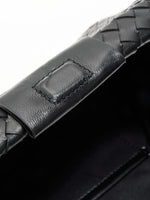 Black Weave handwoven sheepskin chain baguette bag close-up of the leather tab and frame edge