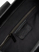 Pebbled Black cowhide chain baguette bag close-up of the interior zip pocket and pebbled leather trim
