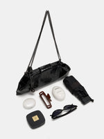 Black Croc cowhide chain baguette bag beside an umbrella, sunglasses, a hair clip, hand cream, and compacts