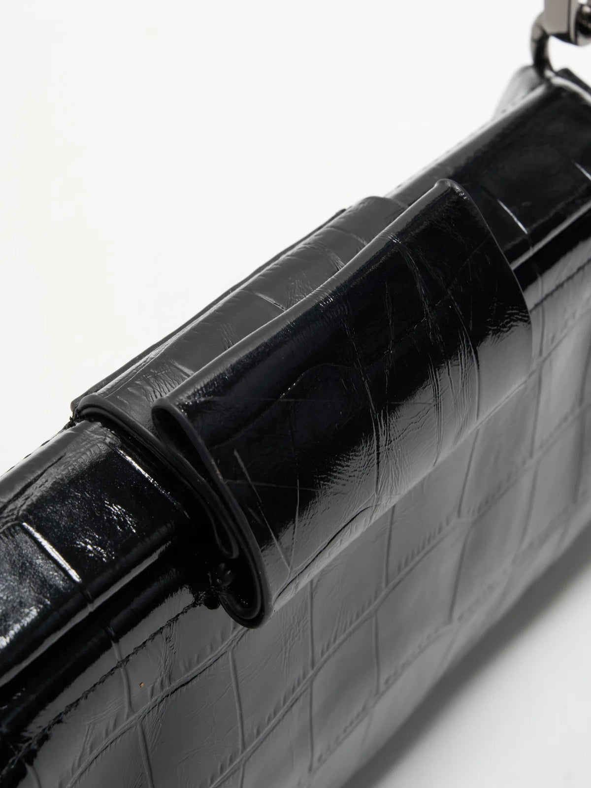 Black Croc cowhide chain baguette bag close-up of the matching magnetic tab and framed top