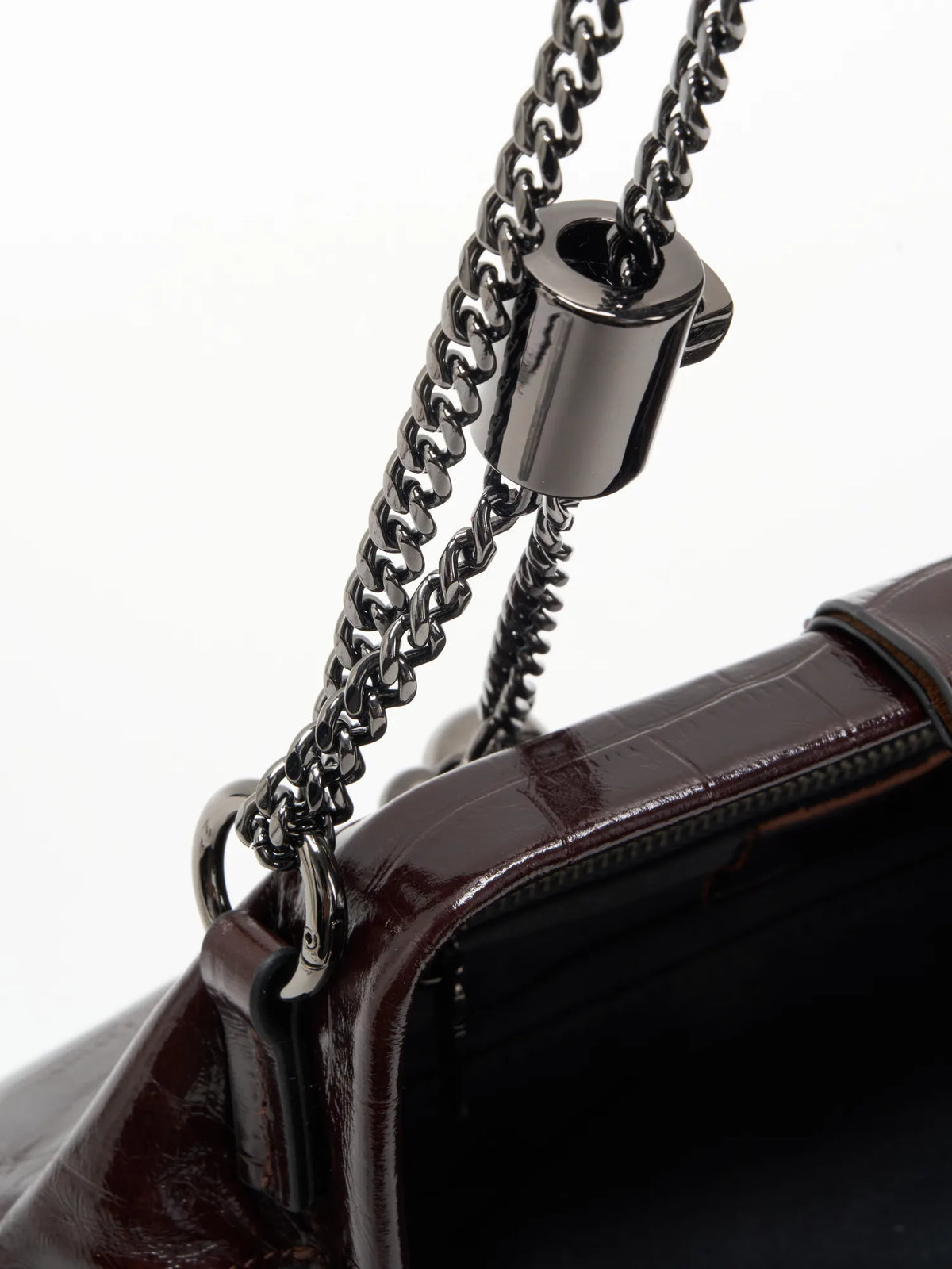 Burgundy Croc cowhide chain baguette bag close-up of the adjustable chain fitting and glossy frame edge