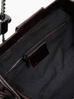 Burgundy Croc cowhide chain baguette bag close-up of the interior zip pocket and burgundy trim